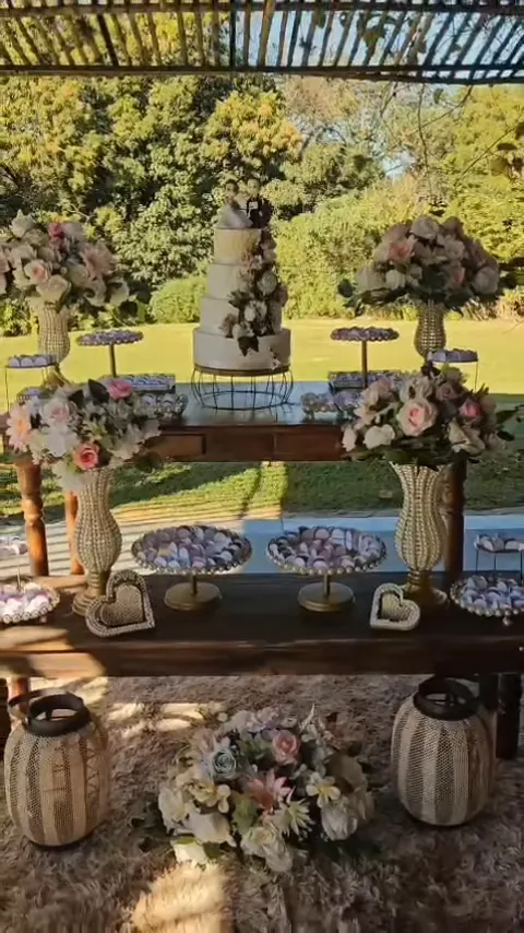 Mesa de doces e bolo de casamento sob a pérgola