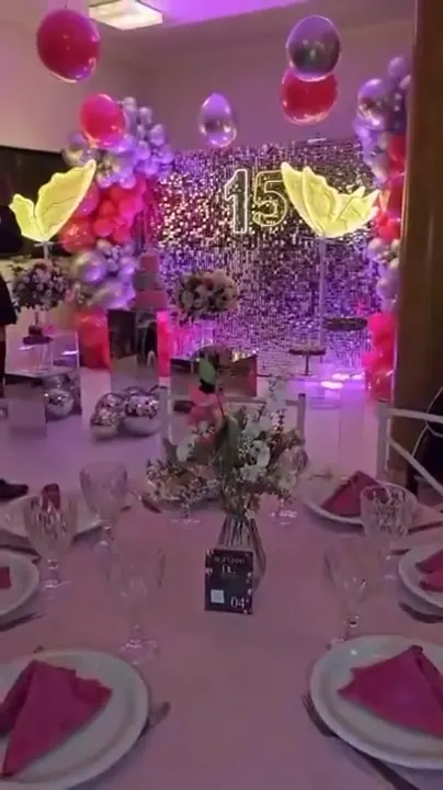 Mesa decorada com letreiro neon 15 ao fundo